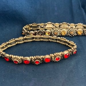 2 6” stretch bracelets, one with gold stones, one with red stones. NWOT